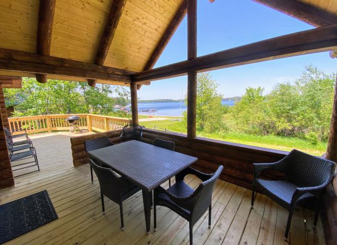 Covered porch area with seating and views of the beach.