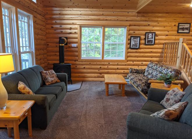 Living room with couch, loveseat, futon, and gas fireplace.