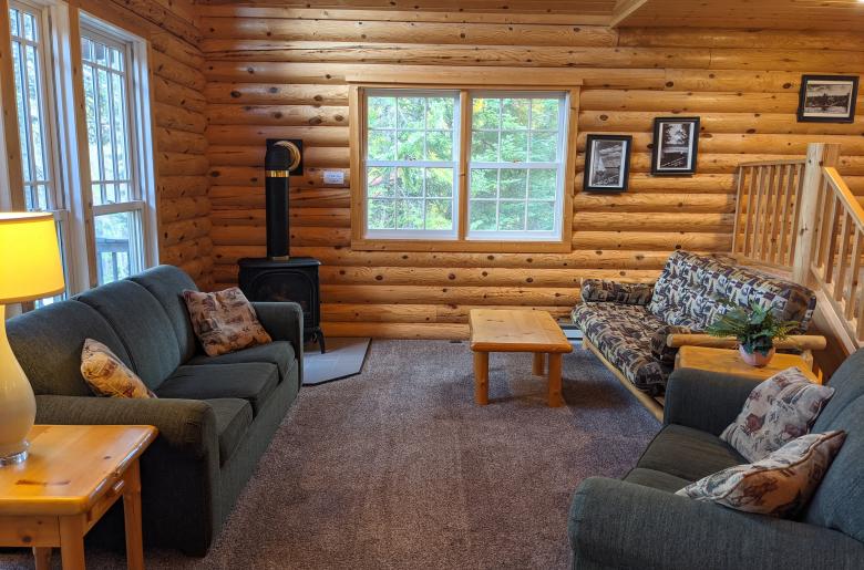 Living room with couch, loveseat, futon, and gas fireplace.