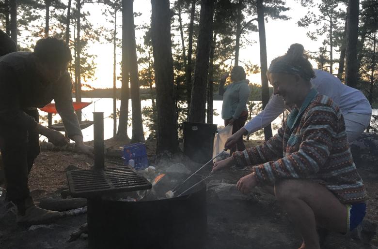 Family roasts marshmallows outdoors at a cookout on Lake Vermilion