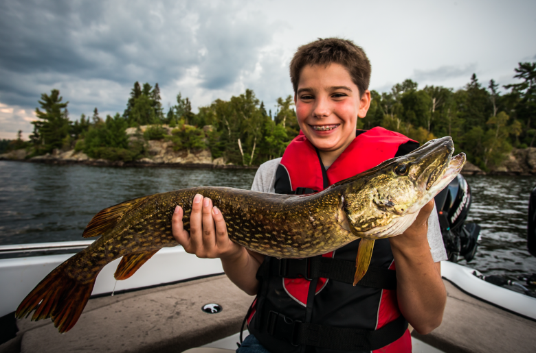 Boy holding a northern pike