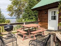 Deck area with picnic table, charcoal grill, and views of the lake.