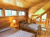 Loft bedroom with a queen and twin bed, as well as an ensuite bathroom.