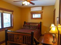 Main floor bedroom with a queen bed and sink.